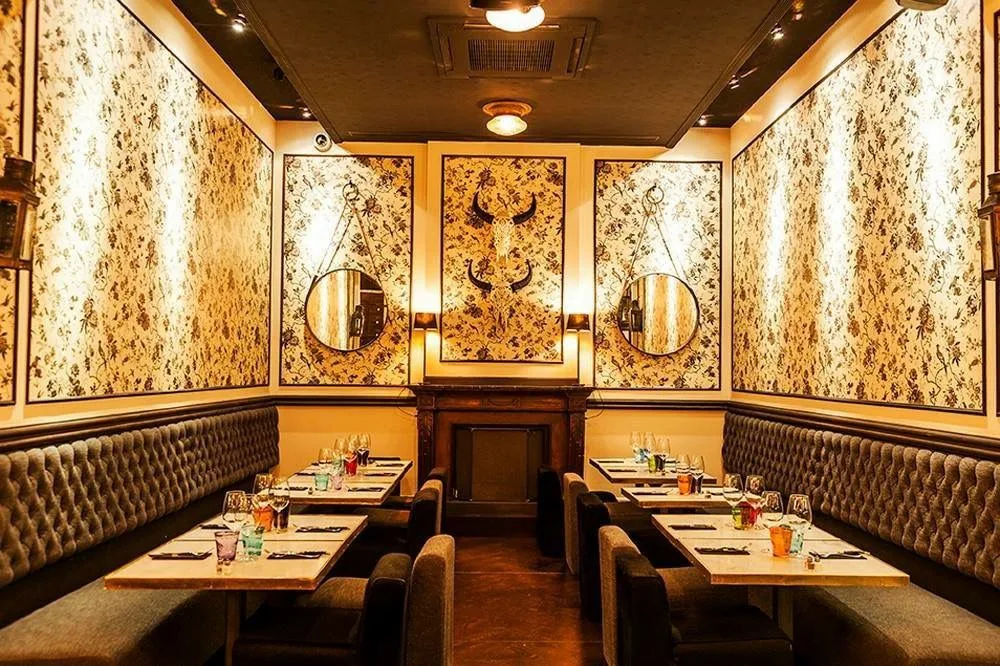 Sala privada con papel pintado y espejos para comidas de grupo en Pepito